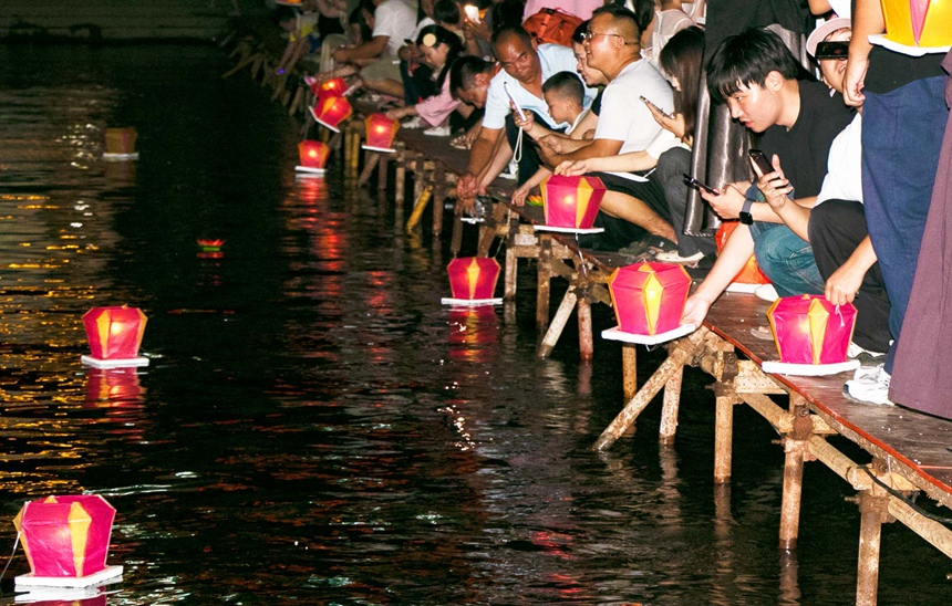 当地居民和游客放河灯祈福