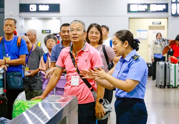 桂林北站工作人员向银发旅客答疑解惑。郑长贤摄