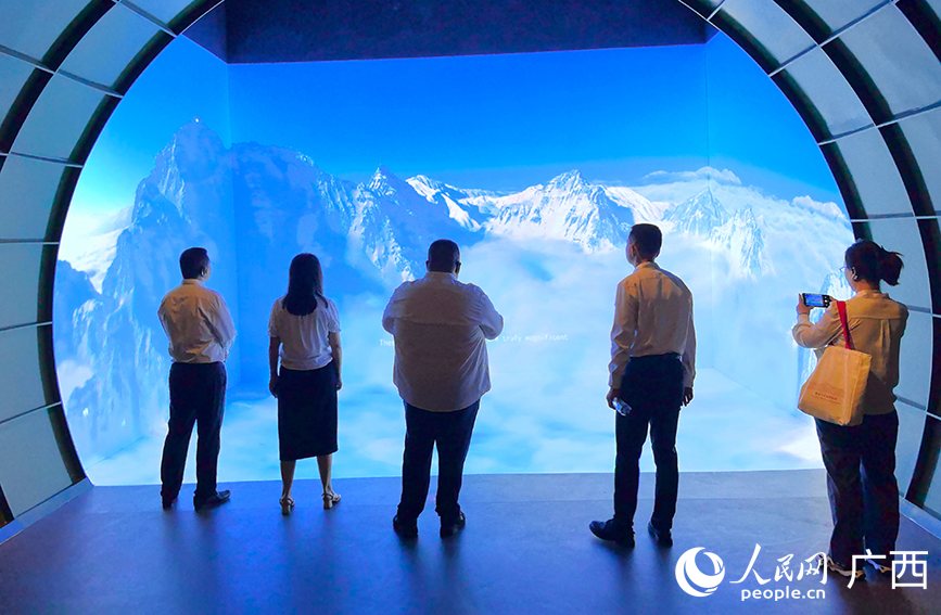 与会嘉宾沉浸式观看穿越驼峰航线视频。人民网 付华周摄