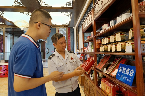 税务工作人员在“退税商店”了解六堡茶出口产品，宣传离境退税政策。莫杰昌摄