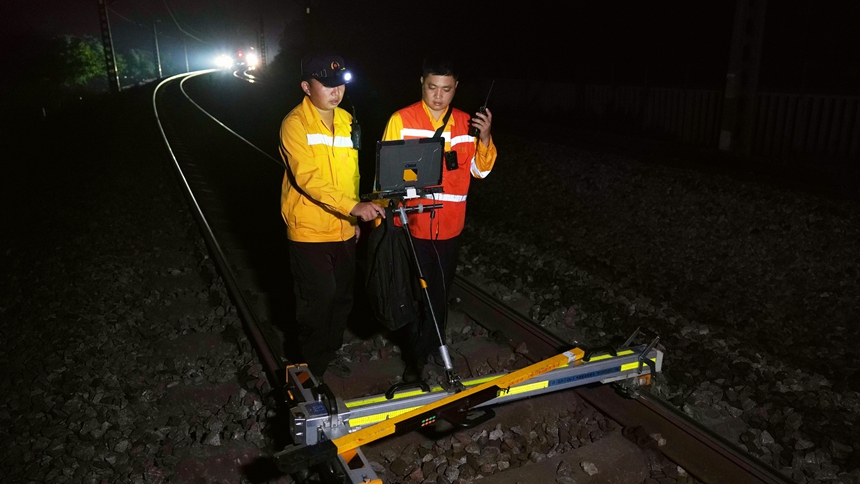 作業人員檢查搗固后線路的軌距、水平、高低等數據。陳健攝