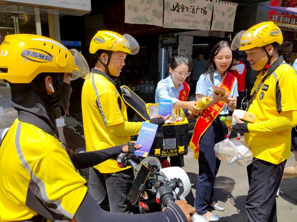 工作人员向“新市民”讲解金融知识。车炫冰摄