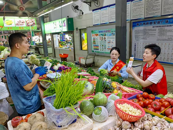 工作人员向商户讲解金融知识。唐谨云摄