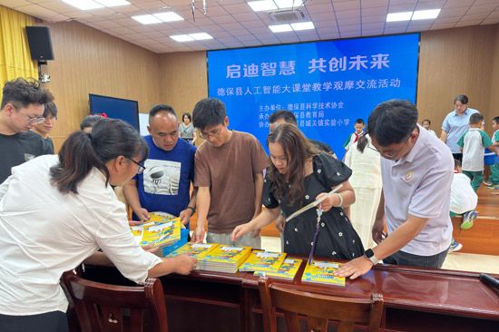 德保縣人工智能大課堂教學觀摩交流活動現場向學員贈送AI教材。黃勝高攝