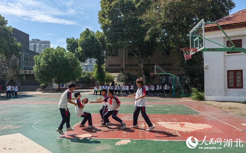 学生们在操场上打篮球。
