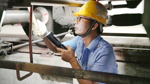 軌道作業車司機檢查制動部件。蔡星宏攝
