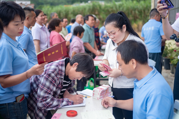 板鑾村合作社股民簽字領取分紅。李天一攝