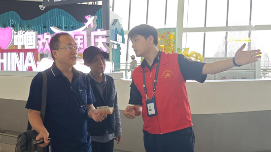 青年團員志願者引導旅客辦理登機手續。王劍攝