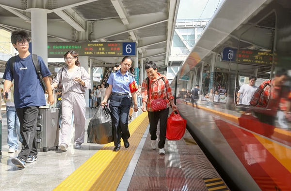 國慶中秋雙節假期期間，桂林火車站黨員骨干為旅客提攜行李。鄭長賢攝