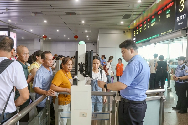 國慶中秋雙節假期期間，桂林火車站客運工作人員為旅客辦理檢票業務。鄭長賢攝