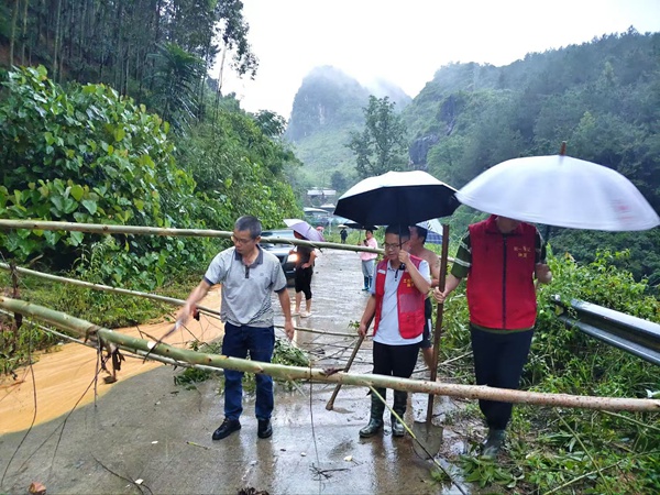 梁瑞聪(左一)清理倒下的树木,以保障群众出行。隆桑镇人民政府供图