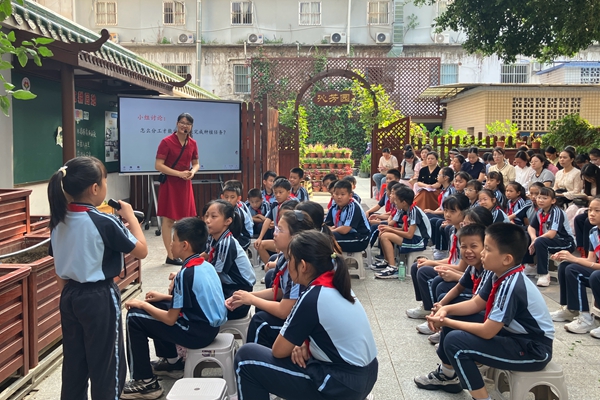 南宁市衡阳路小学邱炎娟与学生在劳动基地上劳动教育课《探秘绞股蓝世界》。韦莹摄
