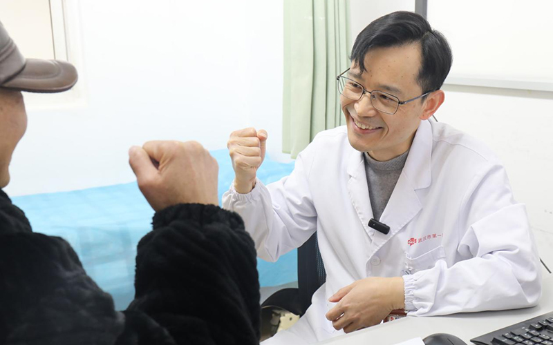 感动'医'瞬间二等奖作品《胸外科专家门诊诊室内，主任医师罗东与患者鼓劲加油》。代雨朦摄