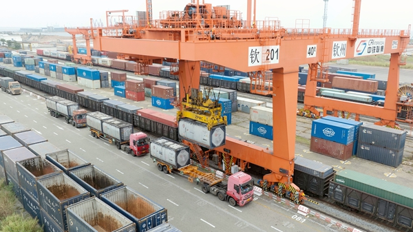 在廣西欽州鐵路集裝箱中心站,自動化龍門吊正在吊裝汽運集裝箱貨物。陳磊攝