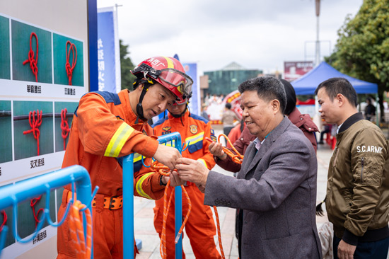 消防救援人員在教授群眾如何系消防繩結。邱曉宇攝