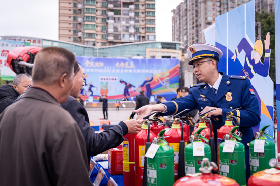 消防監督員在向群眾科普消防器材的使用方法。邱曉宇攝