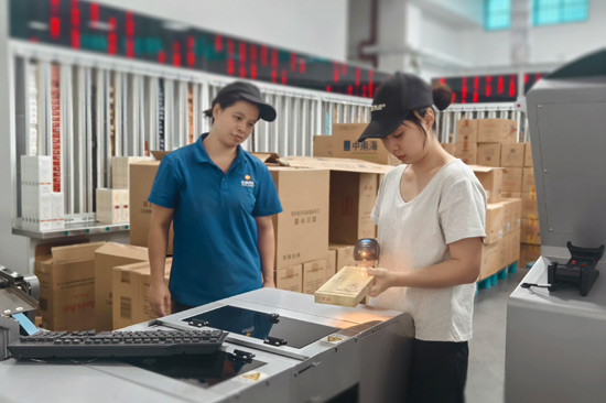 青年员工鲁凯容（右）在分享异型烟快捷扫码分拣技巧—陈美瑛摄