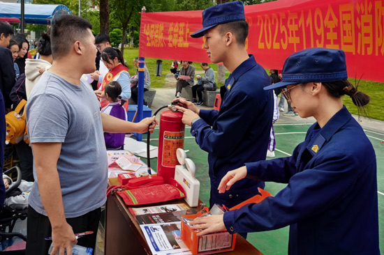 消防宣傳員向群眾講解消防器材使用方法。何小翠攝