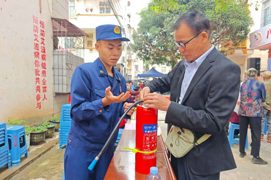 宣傳人員向居民講解滅火器的使用方法。
