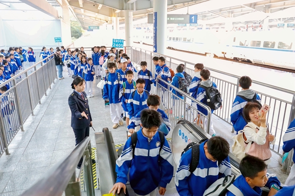 桂林火车站客运工作人员在电梯口为研学团做好安全防护。郑长贤摄