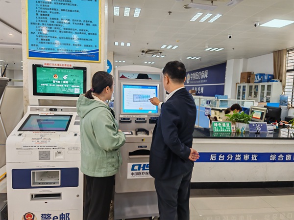 马山县医保业务经办人员通过自治区医保自助服务一体机帮助参保群众查询医保业务