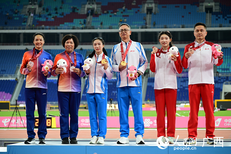韋永麗（左一）與教練田玉梅（左二）登上領獎台。人民網 雷琦竣攝