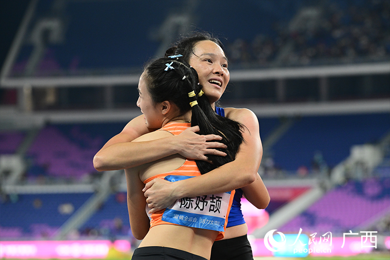 韋永麗與年輕冠軍陳妤頡相擁在一起。人民網 雷琦竣攝