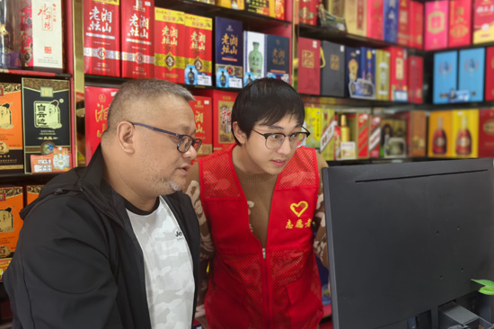 灵川烟草志愿者正在指导零售客户操作云POS扫码系统 毛剑摄