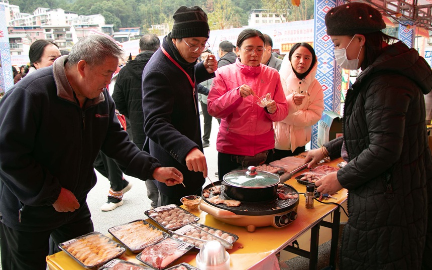 在农特产品展销上，嘉宾群众体验资源美食。