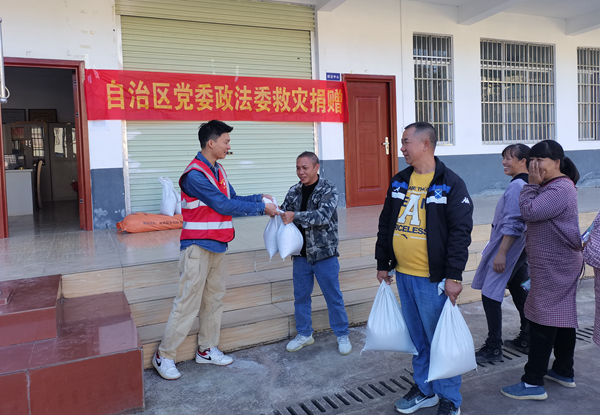 汤亮村村民排队领取自治区政法委捐赠的优质大米。林东婷摄