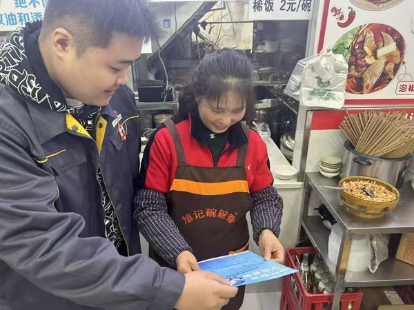 工作人员正在向商户讲解用能成本问题。