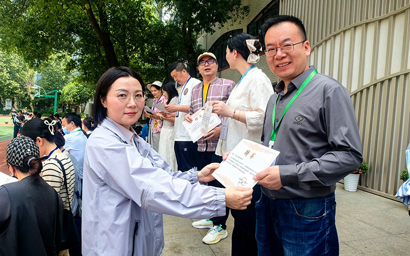武汉市第十二初级中学校长孙晓洁为食堂膳食监督委员会家长委员颁发聘书。
