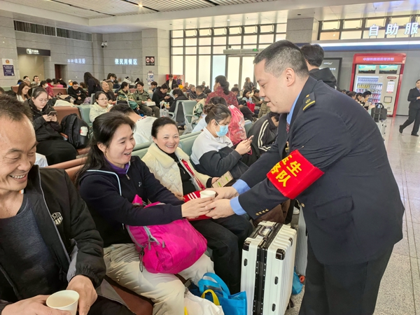 玉林站“刘玉生服务队”队员为专列旅客送上温水。曾莉摄