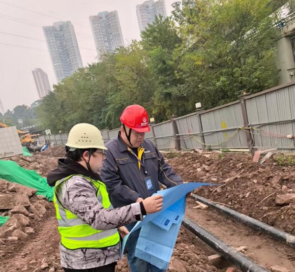 “红岩燃小兵”党员服务先锋队队员与项目人员对照施工图纸，细致核查技术细节。重庆燃气集团供图