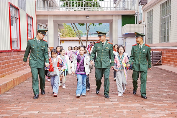 武警官兵携手红瑶女童走进军营。赖治华摄