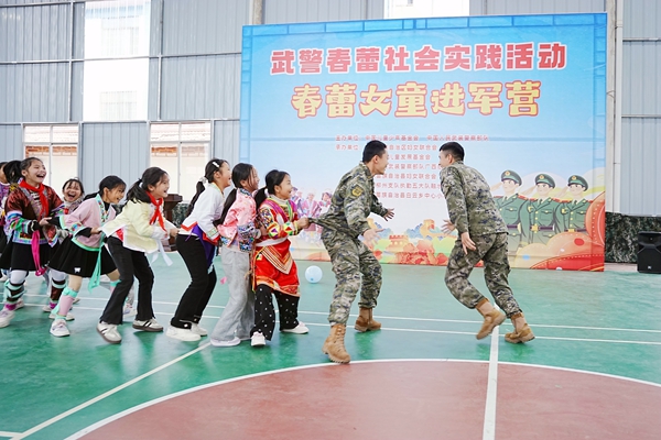 武警官兵与红瑶女童开展互动游戏。赖治华摄
