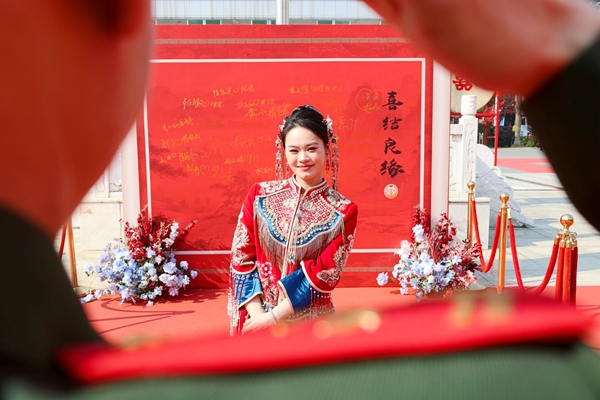 新郎向新娘敬军礼。陈名利摄