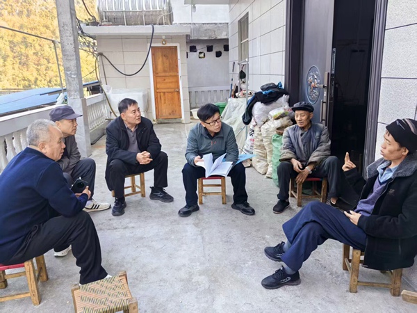 离退休校友正在与患者父子聊家常。右江民族医学院供图