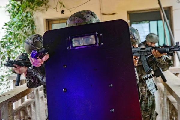 武警官兵在进行小组协同搜索。
