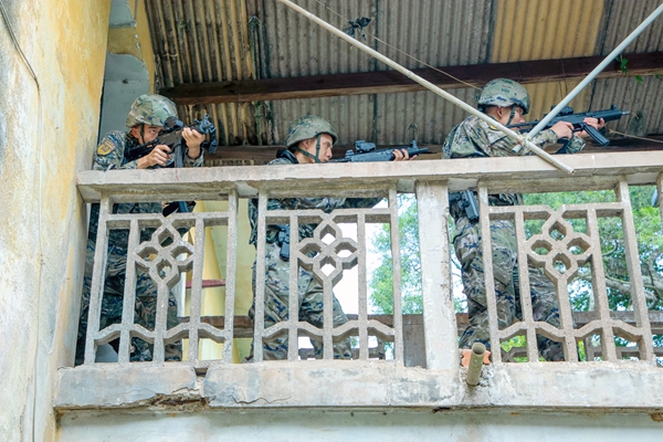 武警官兵在进行小组协同搜索。