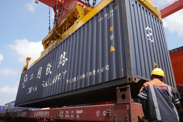 龙门吊正在将装载着板材的集装箱平稳地装在中越班列货车上。陈智彬摄