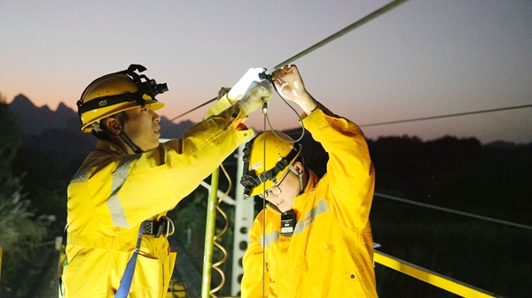 青年突擊隊成員在檢查接觸網吊弦。蔡星宏攝