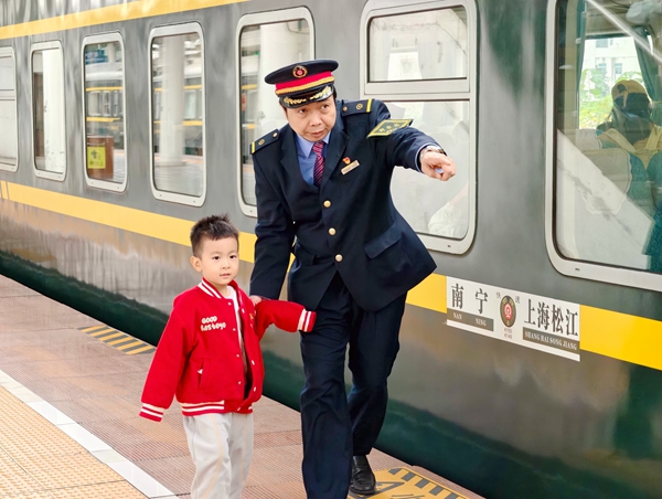 列车长冯庚华在站台为小旅客安全指引。
