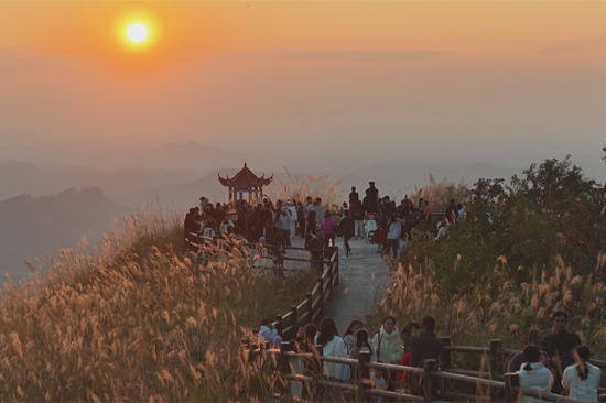 游客在蒲塘镇北寮岭生态森林公园观赏日落美景