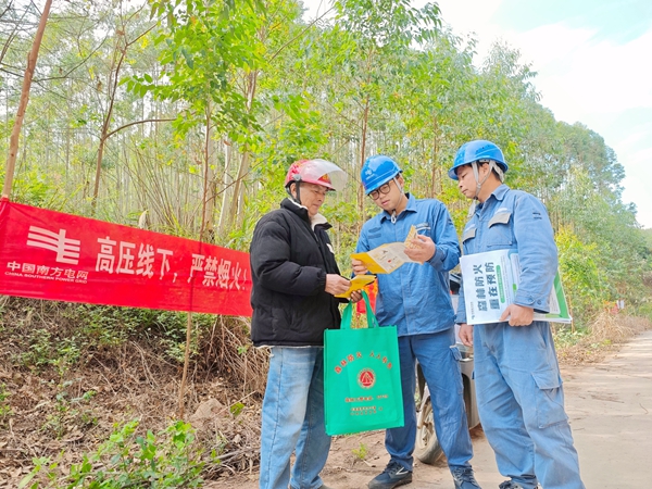 工作人员在山林附近向群众宣传。方天学摄