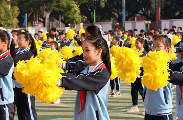 学生们手持黄色花球参与团体操展演