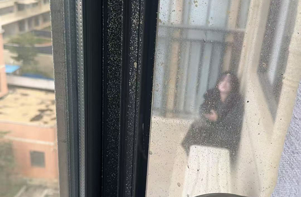 輕生女孩蹲坐在放置空調外機的平台上
