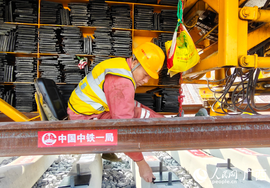 工人正在进行铺轨作业。人民网记者 王勇摄