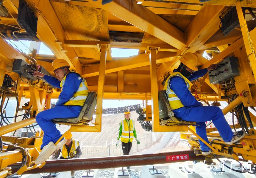 工人正在进行铺轨作业。人民网记者 王勇摄