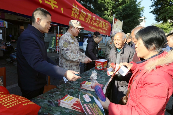 武裝部工作人員向適齡青年及家長宣傳征兵政策。